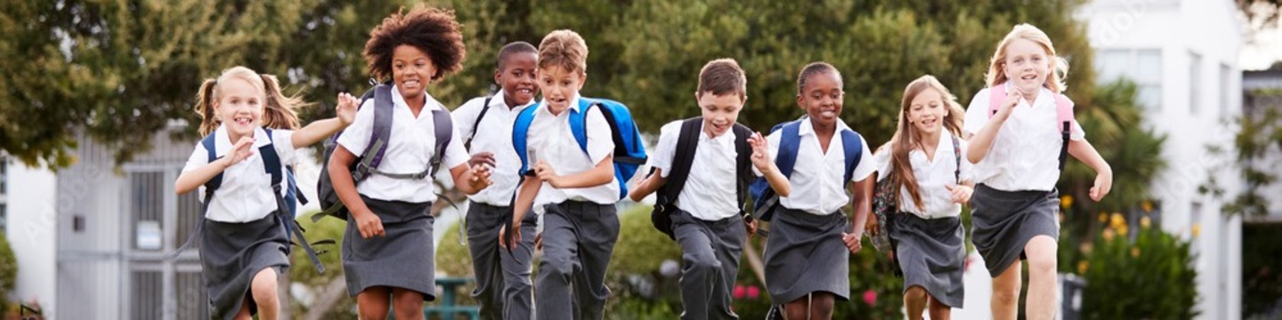 Line of children facing away with coloured back packs 