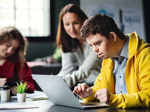 Two people having a conversation looking at a laptop